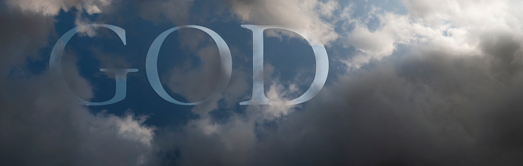 Abstract religious banner. The word GOD written on the sky with clouds and a beam of sunlight.