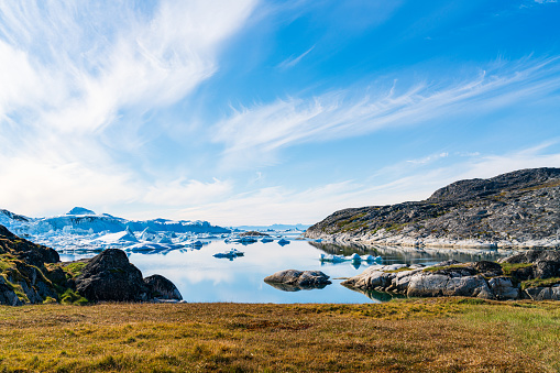 Greenland arctic nature landscape with icebergs in Ilulissat icefjord. Panoramic photo of scenery ice and iceberg in Greenland in summer. Cruise ship travel destination.