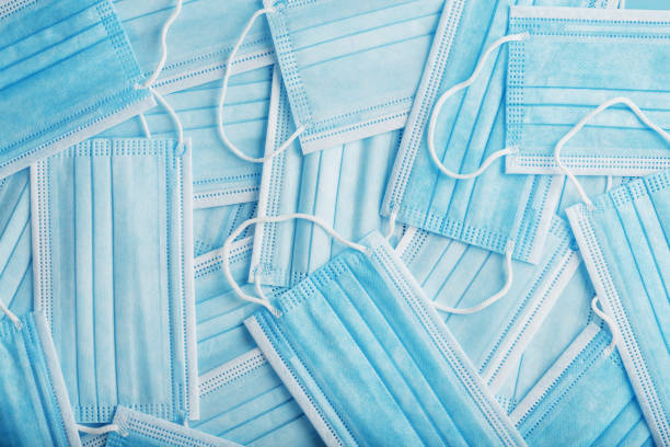 istock Blue medical protective masks are scattered as a background, texture. 1325732143