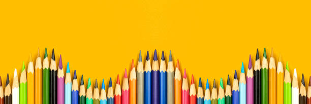 istock School banner with wavy color pencils border on a yellow table background with copy space, top view photo 1325732903