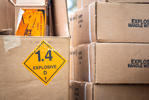 Explosive triangle placard sign on the carton box, to demonstrate the dangerous material inside. Industrial safety sign and symbol on the object.