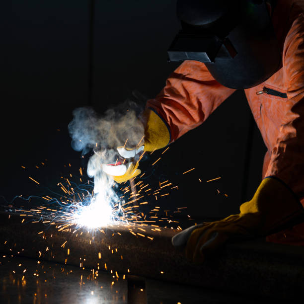 istock Metal industry workers are welding steel sheets for real estate projects received. Sparkler on black background, close-up. Heavy work in factory. 1325737314
