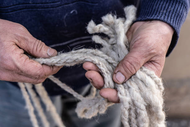 istock Hands of an old man making traditional wool spinning 1325740683