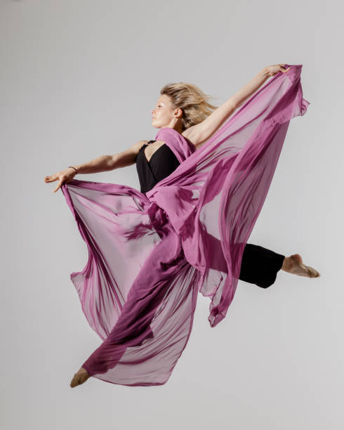 istock Dancer on gray background with textile in the air 1325740860