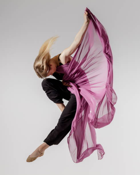 istock Dancer on gray background with textile in the air 1325740864