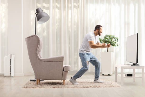 istock Guy at home watching a tv and gesturing happiness 1325740905