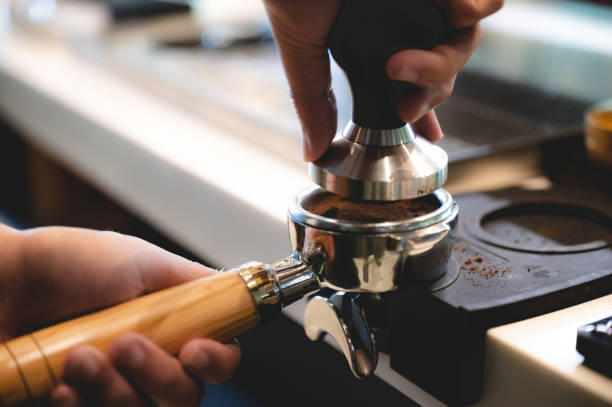 istock professional barista making espresso coffee to a drink cup in cafe, beverage caffeine machine, person pouring hot water with hand, business in the morning breakfast, fresh aroma in hot drink 1325743481