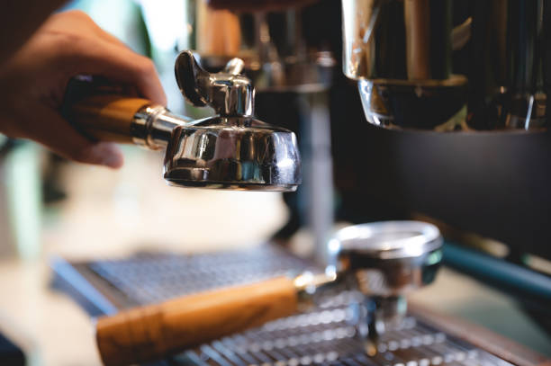 istock professional barista making espresso coffee to a drink cup in cafe, beverage caffeine machine, person pouring hot water with hand, business in the morning breakfast, fresh aroma in hot drink 1325743570