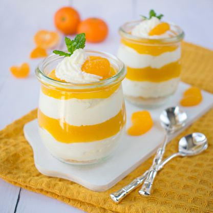 A light, fluffy layered dessert with the addition of cream cheese, mandarin mousse, whipped cream and fresh pieces of fruit.