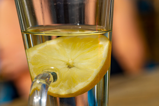 Hot water with a lemon slice to make a hot lemon drink.