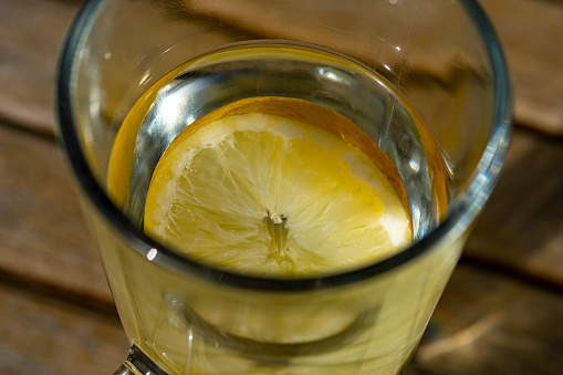 Hot water with a lemon slice to make a hot lemon drink.