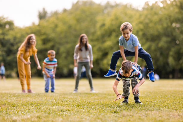 gruppe von kindern, die im öffentlichen park spielen - leapfrog stock-fotos und bilder