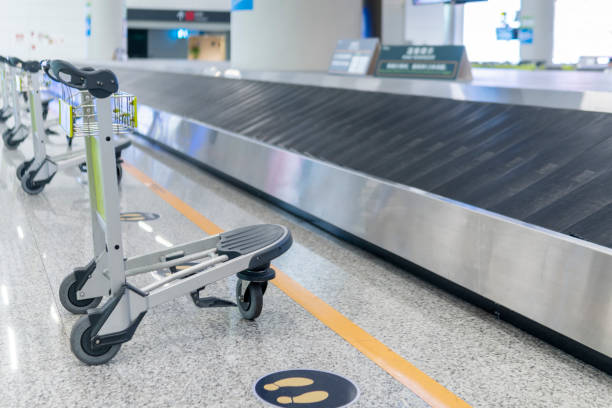 istock Airport luggage trolley carts besides the baggage conveyor 1325748385