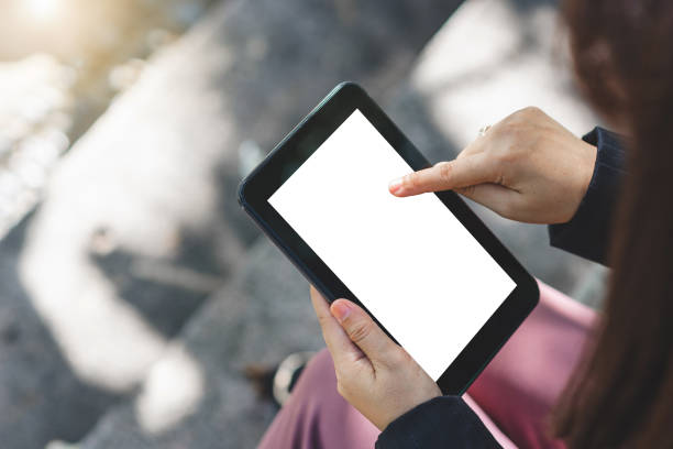 istock close up business woman hands using smartphone tablet typing and touch on white screen for working with app devices vintage style in park with sunrise and blur nature background. 1325753531