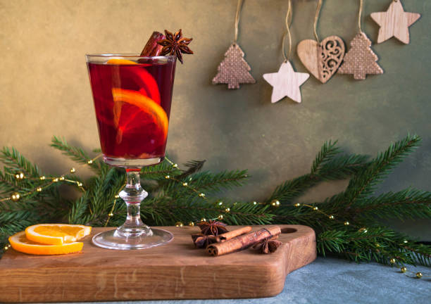 istock Mulled wine with spices and a Christmas tree on a green background. 1325760877