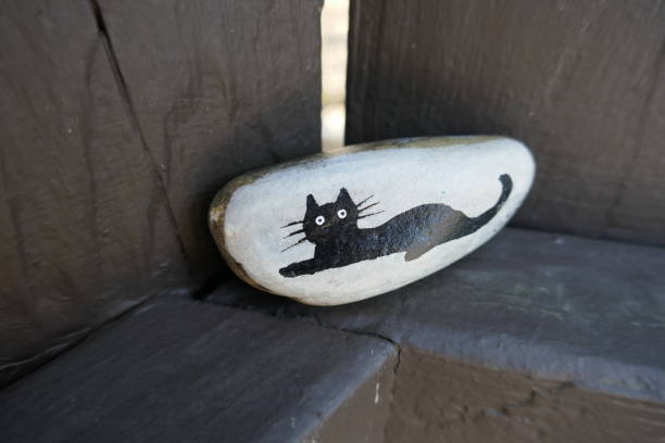 Black cat silhouette painted onto kindness rock