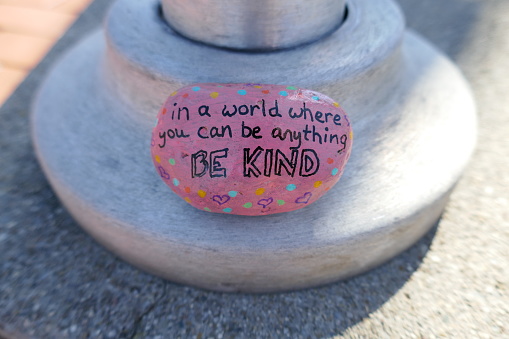 Sea amable mensaje pintado en la roca de la bondad rosa photo