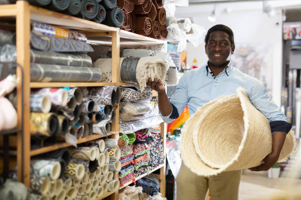 istock Male shopper chooses floor mat in store 1325767457