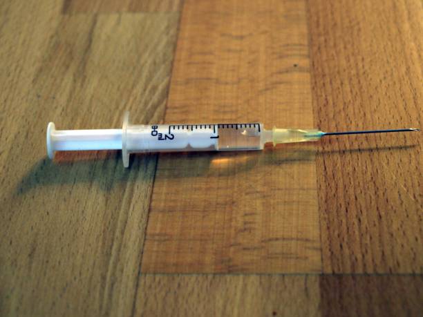 istock Mounted syringe lies on the wooden table 1325768896