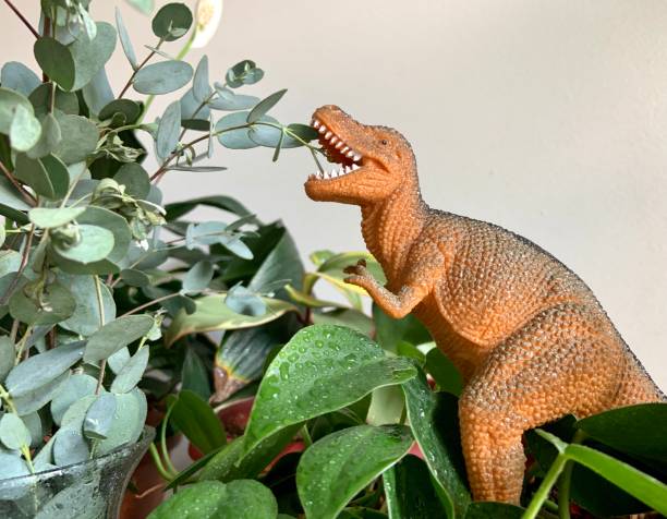 istock Toy Dinosaur Eating Plant Leaves 1325770154