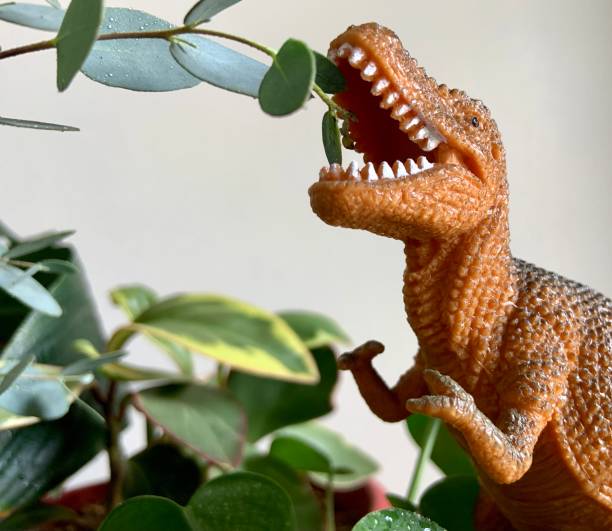 istock Toy Dinosaur Eating Plant Leaves 1325770156