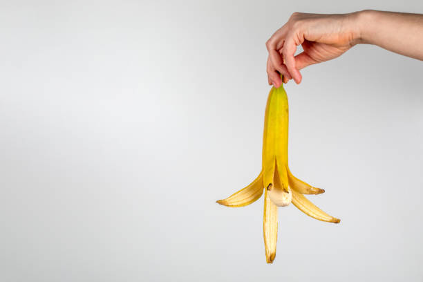 istock Peeled banana in a woman's hand on a white background 1325772366