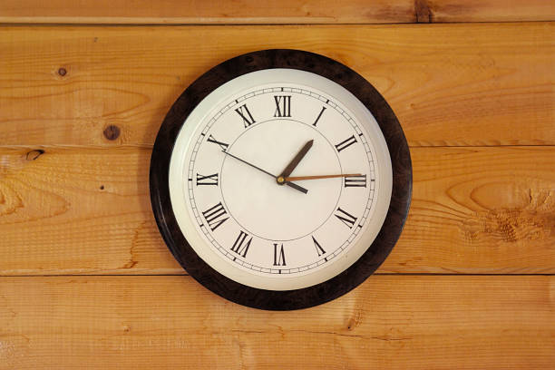 istock round white clock on a wooden wall 1325772601