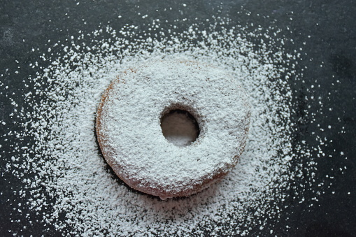 donut and powdered sugar on a black background,