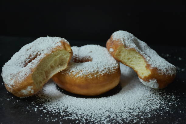 istock donut and powdered sugar on a black background, 1325773404