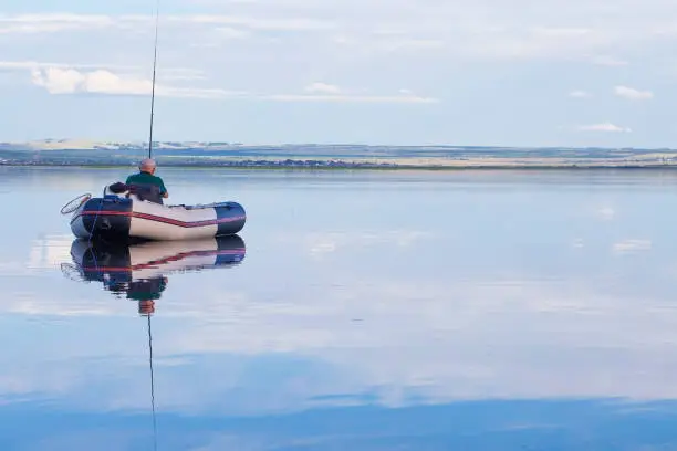 Photo of Adult male fisherman in a boat at daytime