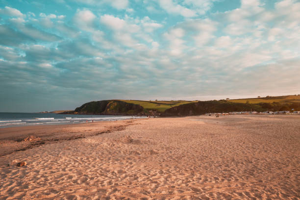 istock Cornwall beach at sunset, coast, shore with surfers and people 1325789003