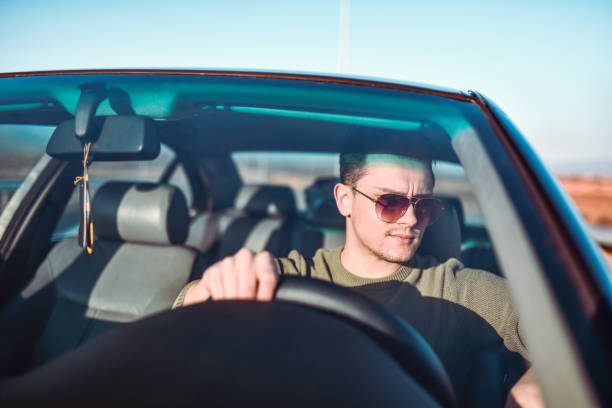 istock Handsome Male Driving His Car On Highway During Sunset 1325790089