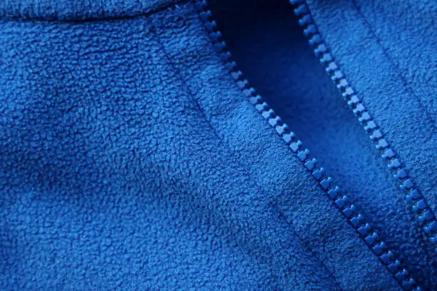 Close shot of simple blue fleece fabric with zip fastener