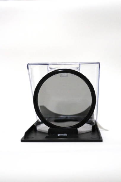 Isolated filter lens on white background, vertical image. Photography equipment, accessory. Plastic box