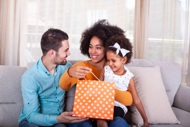 istock Parents giving present to daughter at home 1325797312