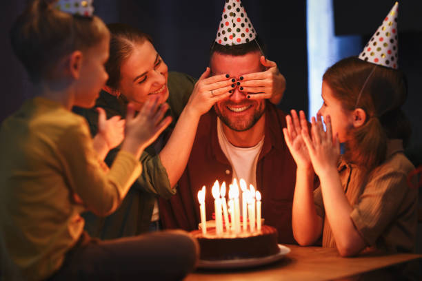 istock Young man father going to blow candles on chocolate cake while celebrating his Birthday with family 1325802652