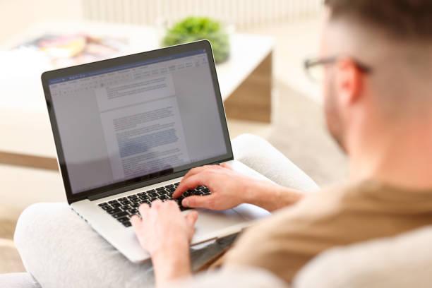 istock Male freelancer working with document online while sitting on sofa at home 1325802688
