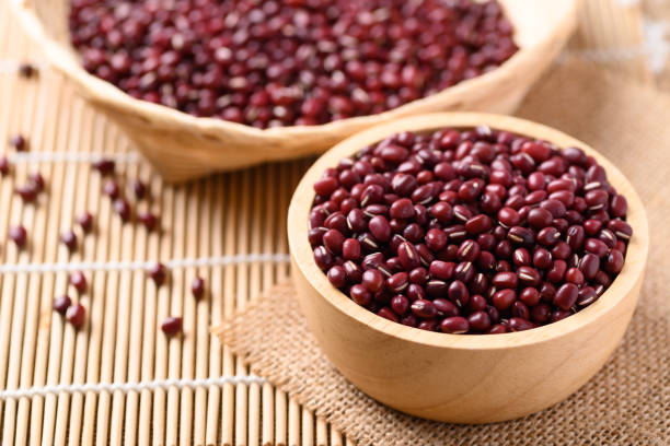 Azuki beans or red mung beans in a wooden bowl stock photo