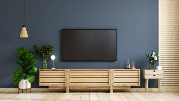istock Wall mounted tv on cabinet in modern empty room with behind the dark blue wall. 1325825427