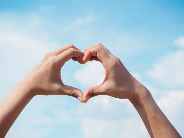istock Heart shape hand on blue sky and fluffy cloud background. 1325826665