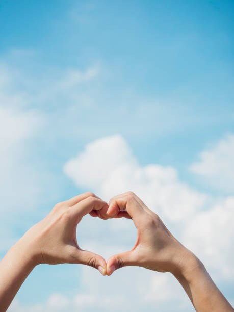 istock Heart shape hand on blue sky and fluffy cloud background. 1325826668