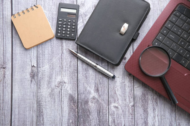 istock magnifying glass, notepad and laptop on wooden background 1325832343