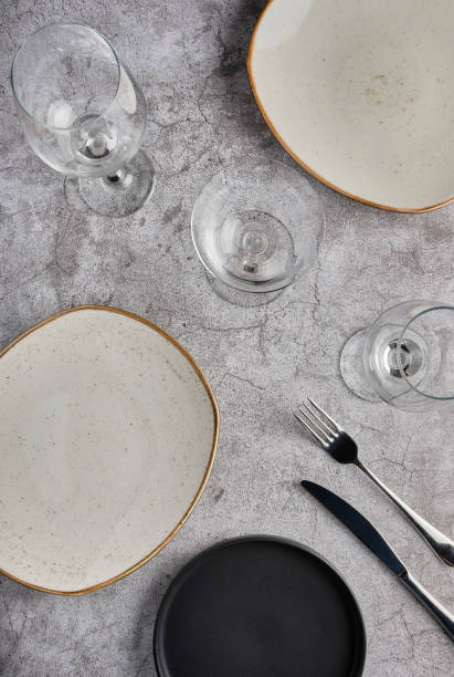 istock Empty plates, forks and glass of wine on grey concrete background, mockup. 1325834799