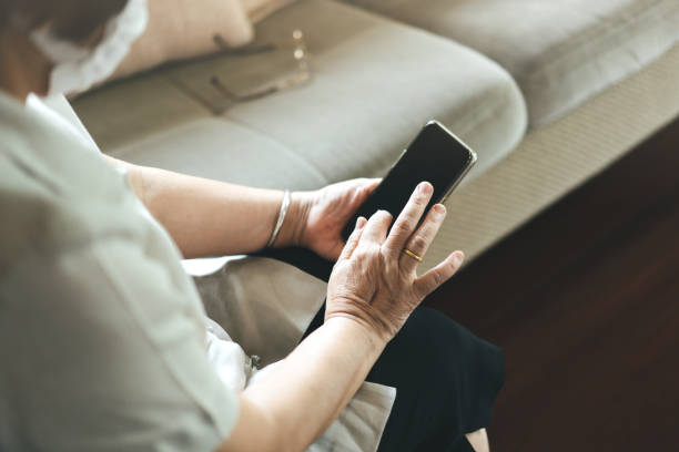 istock Asian elderly woman wear mask using smartphone. 1325837687