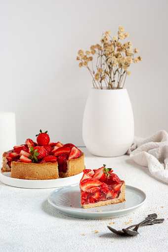 A piece of summer pie with fresh strawberry on a plate, ready to eat