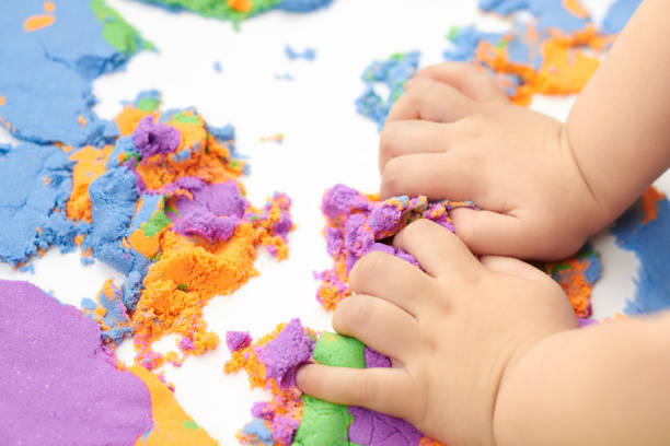 istock Little boy's hands on bright kinetic sand 1325839616