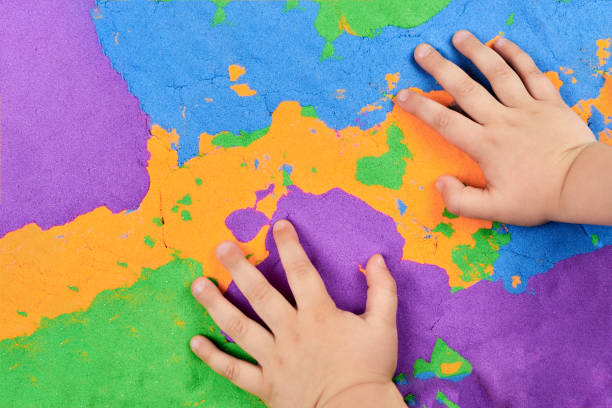 istock Little boy's hands on bright kinetic sand 1325839641