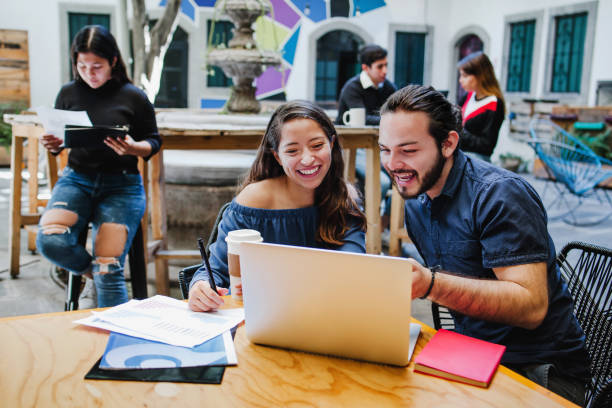 happy young mexican college students working together on laptop in latin america - mexican ethnicity imagens e fotografias de stock