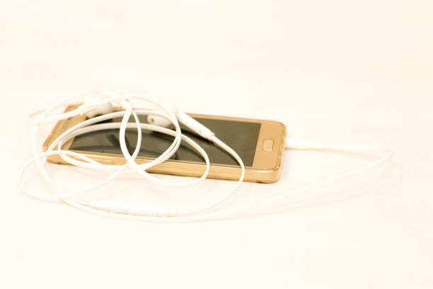 istock Smartphone with blank screen and white earphones on the white background side view 1325841726