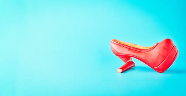 istock Chocolate women's shoes on a blue background. Broken shoe, female problem 1325844702